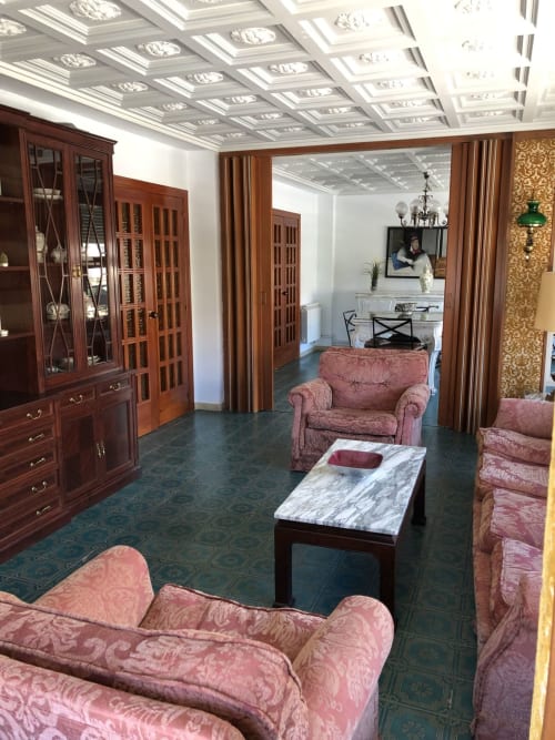 Elegante sala de estar del hotel Casa María en Artana con muebles tapizados en rosa y detalles de madera ornamentada