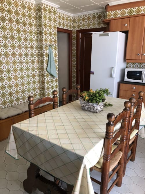 Comedor retro del hotel Casa María en Artana con muebles de madera, papel tapiz estampado y mesa de comedor