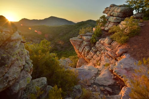 Atardecer dorado sobre acantilados rocosos y verdes valles cerca de Casa María en Artana, España