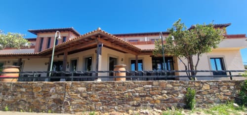 Hotel Atalaya in Guadalupe, Cáceres - terrace with stone wall, wooden beams, and mountain views