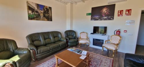 Spacious hotel lounge at Hotel Atalaya in Guadalupe with leather seating, fireplace, and modern amenities