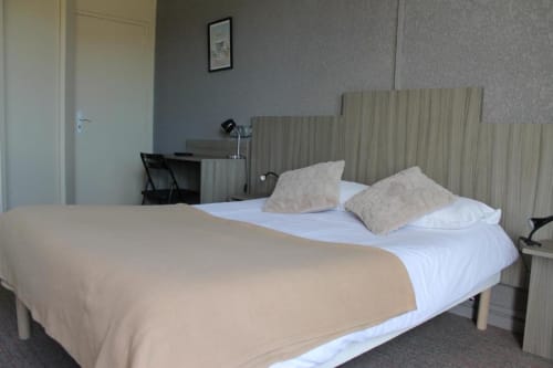 Comfortable double room at Libre Hôtel with white bedding, beige pillows, and striped headboard overlooking garden