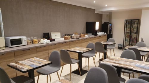 Libre Hôtel breakfast room in La Vespière with dining tables, gray chairs, and buffet counter with appliances