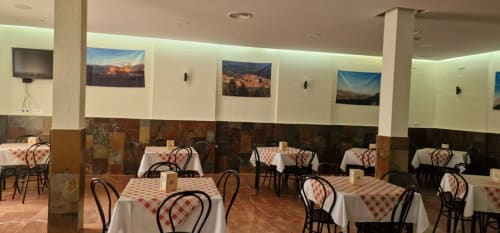 Hotel Atalaya dining room in Guadalupe, Cáceres with checkered tablecloth tables and scenic wall art