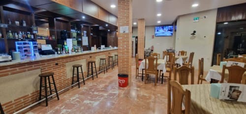Hotel Atalaya bar and dining area in Guadalupe, Cáceres with wooden furniture and brick counter