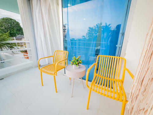 Sillas amarillas modernas en balcón con vista al jardín del hotel La Puerta del Angel en Ricaurte, Colombia