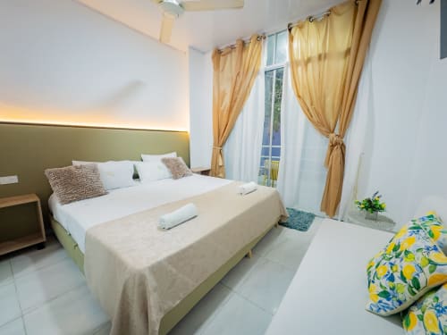 Moderna habitación doble en La Puerta del Angel con cabecera verde, balcón con vista al jardín y decoración tropical en Ricaurte