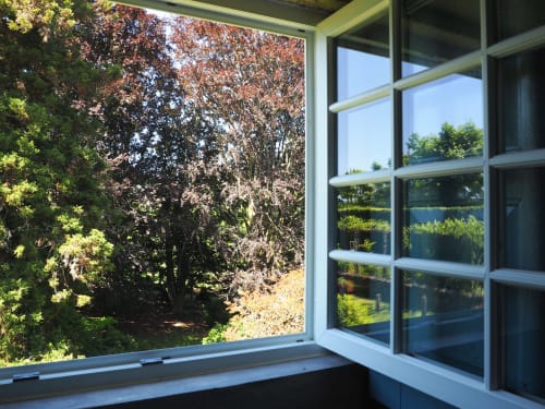 Vista da janela de canto do apartamento da Quinta da Coutada com árvores de outono e paisagem verdejante em Arcos de Valdevez