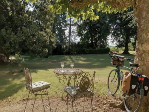 Vélo garé près d'une table et de chaises en fer forgé sur la pelouse du Clos Ceres B&B à Viré, Bourgogne