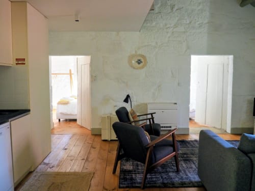 Sala de estar integrada com cozinha num apartamento T2 em Quinta da Coutada, com pavimentos em madeira e vista para jardim