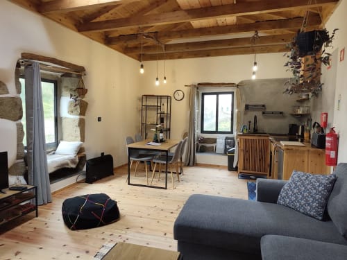 Casa Azorina villa living room with wooden beams, sofa, dining table, and mountain views in Fajazinha