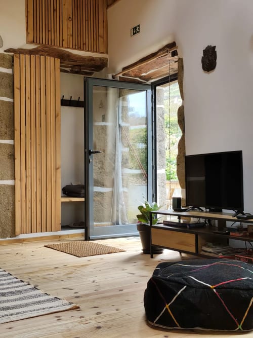 Modern villa living room at Casas Florescer with wooden beams, glass doors opening to mountain views, TV, and minimalist