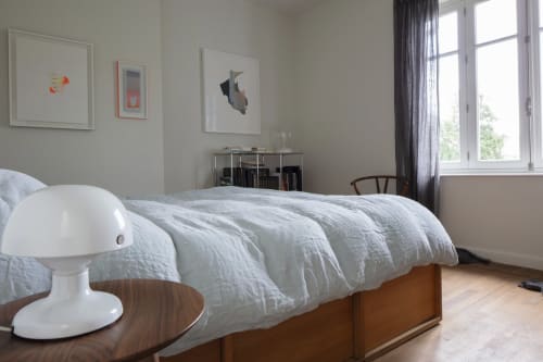 Chambre lumineuse à la Villa Sonneville à Roubaix avec literie blanche, lit en bois, vue sur jardin et design minimaliste moderne