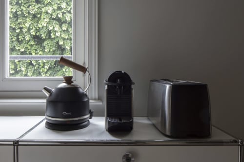 Black kettle, coffee maker, and toaster on windowsill at Villa Sonneville with garden view, Roubaix