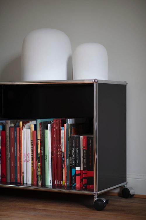 Bibliothèque moderne à cadre noir et roulettes présentant des livres colorés à Villa Sonneville, Roubaix