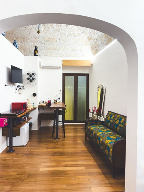 Appartamento Paradiso Soprano 1 di CorteLirice: soffitto in pietra a volta, soggiorno arredato con divano decorato, angolo cottura, zona lavoro