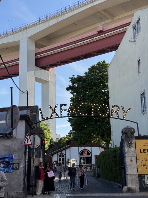 Entrada do cabaret Xery com letreiro luminoso sob viaduto elevado em Ribeirinha, Portugal