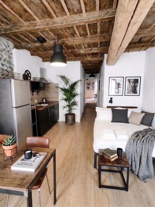Moderno monolocale a Bergamo con travi in legno a vista, angolo cottura, letto e zona living