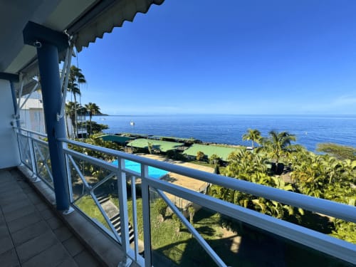 Balcony view at Horizon Doré hotel in Gourbeyre, Guadeloupe with ocean, palm trees, and pool