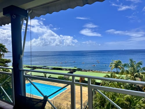 Horizon Doré balcony view overlooking pool, tropical gardens, and Caribbean Sea in Gourbeyre, Guadeloupe