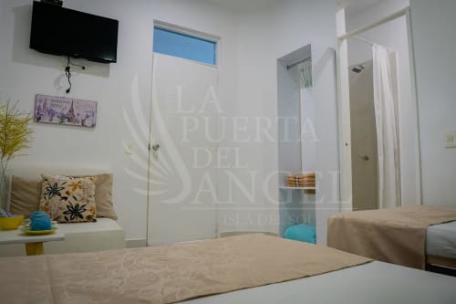 Habitación moderna en La Puerta del Angel, Ricaurte, con cama doble, sala, TV y acceso al baño