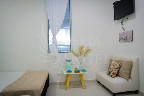 Habitación luminosa en La Puerta del Ángel con cama doble, zona de estar, ventana con vista a las montañas y amenidades modernas