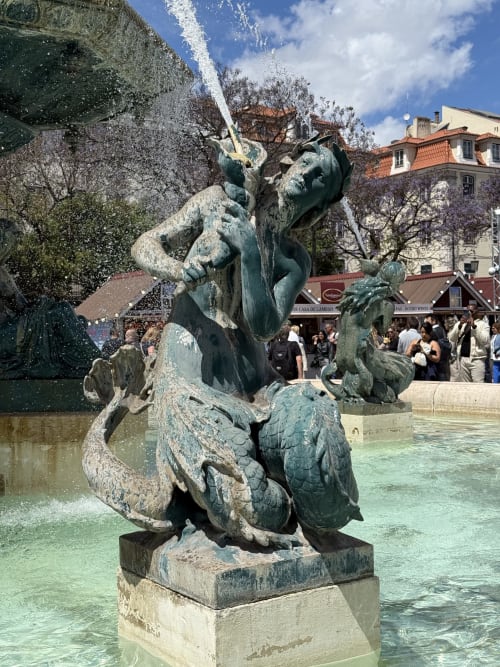 Escultura de fonte em bronze com água jorrando na praça da cidade de Ribeirinha, perto da Vila da Sereia Dourada