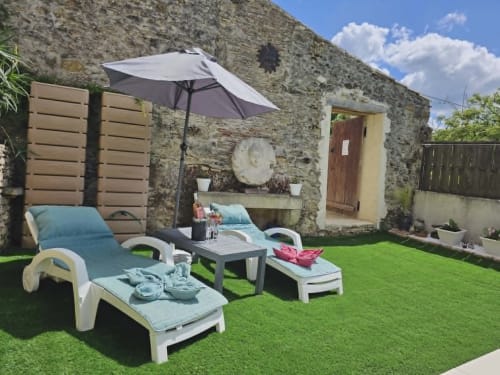 Terrasse de jardin romantique avec transats, parasol et chaumière aux Secrets de Winna, Deux-Sèvres