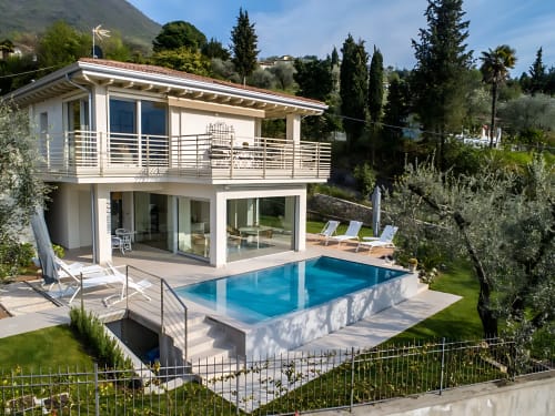 Verdolivo B&B a Sale Marasino: architettura moderna bianca con piscina, terrazza e vista sulle montagne.