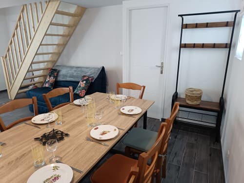 Dining area in Maison La Tour Penchée at Les Meublés d'Hélène with wooden table, wooden chairs, and blue sofa