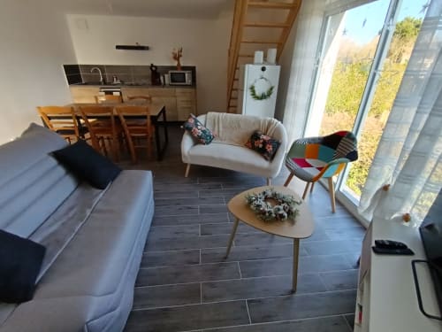 Lumineux séjour ouvert avec canapé design, table à manger et cuisine à l'appartement Les Escardines, Sainte-Marie-Kerque