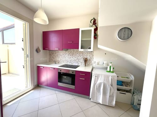 Cucina moderna nella Villetta Alba di Puglia Estate con cabinetry magenta vivace, piani di lavoro bianchi e acciaio inossidabile