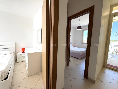 Luminoso corridoio della camera presso Villetta Alba, Puglia Estate, a Santa Maria al Bagno, con pavimento in piastrelle e legno scuro