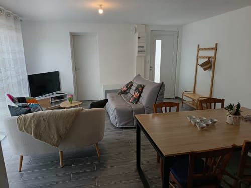 Séjour moderne avec table à manger, canapé, téléviseur et mobilier en bois aux Escardines à Sainte-Marie-Kerque