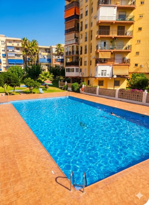 Piscina reluciente y terraza del complejo Torre Sol Y Playa en Torremolinos con edificios de colores vibrantes