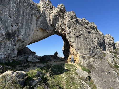 Natural rock arch formation in Alicante mountains near Casa Gallinera vacation home, showing limestone peaks and scenic landscape