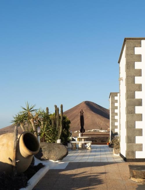 Villa Estrella Polar terrace in Tahiche with volcanic mountain view, palm trees, and modern architecture
