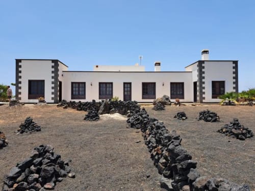 Villa Estrella Polar exterior in Tahiche with white and dark stone facade, mountain views