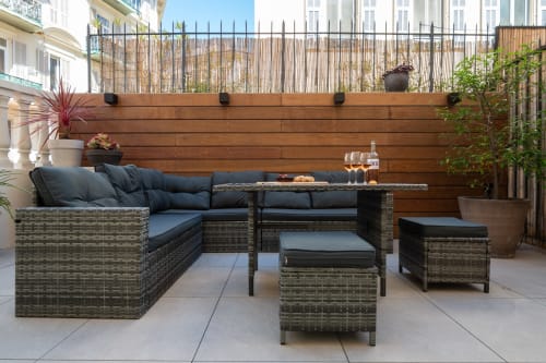 Modern wicker patio furniture with blue cushions on terrace at Enjoy Nice hotel apartment in Nice, France