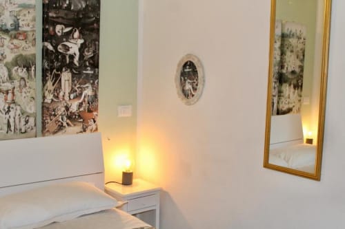 Camera moderna della Guest House Green Gate a Pisa con letto bianco, lampada comodino, specchio e opere d'arte incorniciate alle pareti