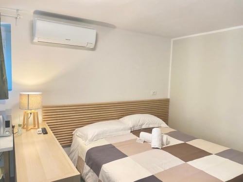 Modernes Einzelzimmer im The Green Gate Airport Guest House in Pisa mit Holzkopfteil, weißer Bettwäsche und Klimaanlage