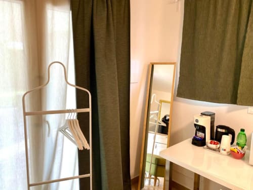 Single room at The Green Gate Guest House in Pisa with desk, mirror, coat stand, and amenities including coffee machine and
