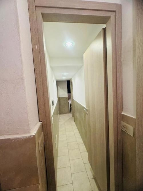 Bright hallway corridor in two-bedroom apartment at Neapolis Tecnotourist with tile flooring and wooden doors