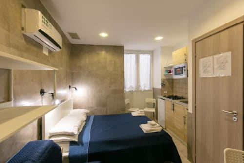 Studio room at Neapolis Tecnotourist B&B with double bed, kitchenette, bathroom and modern furnishings