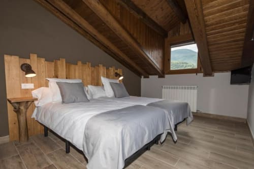 Espacioso dormitorio con vistas a la montaña en el Apartamento Deluxe del Hotel Llibrada, Benasque, con vigas de madera y camas gemelas