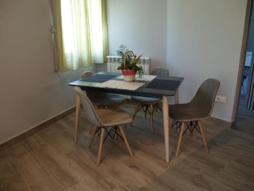 Moderna zona de comedor en El Puente Apartments del Hotel Llibrada, Benasque, con mesa de madera, sillas tapizadas y plantas