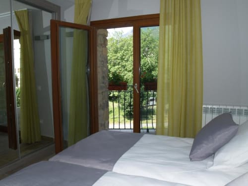 Dormitorio de estudio con puertas a balcón con vistas a la montaña en Hotel Llibrada, Benasque