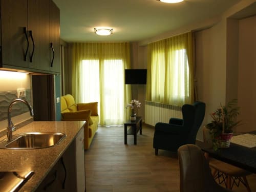 Cocina y sala de estar modernas del Hotel Llibrada en Benasque con vistas a las montañas, mesa de comedor y diseño contemporáneo