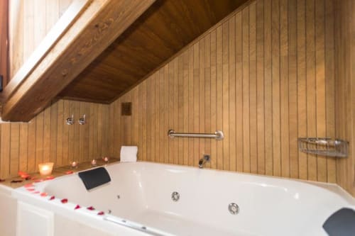 Bañera de hidromasaje de lujo en baño con paredes de madera, vistas a la montaña y servicios de spa en Hotel Llibrada