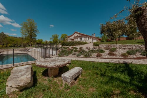 Table et bancs en pierre rustique dans le jardin avec piscine, villa et campagne à Vila Cabanes 46, Le Montat
